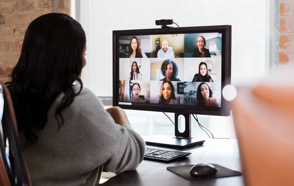 This is a photo of a person in their office who is in a virtual meeting with nine other people.