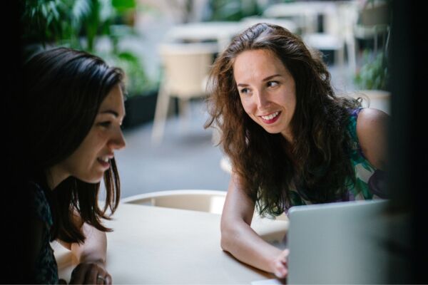 Two Talking Women While Using Laptop