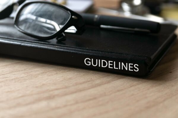 black book with guidelines on spine on table with glasses on top