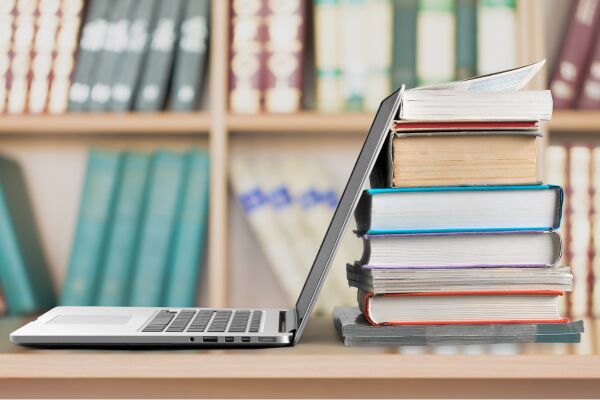Laptop touching library books.