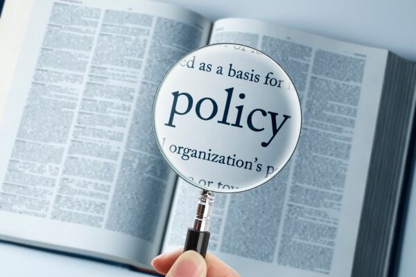 Magnifying glass over a book showing the word policy