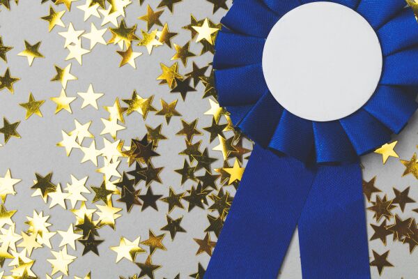 Blue prize ribbon with gold star confetti scattered in background