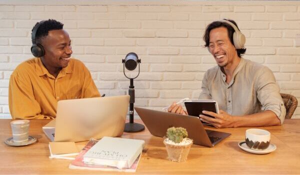 Two cheerful people recording a podcast