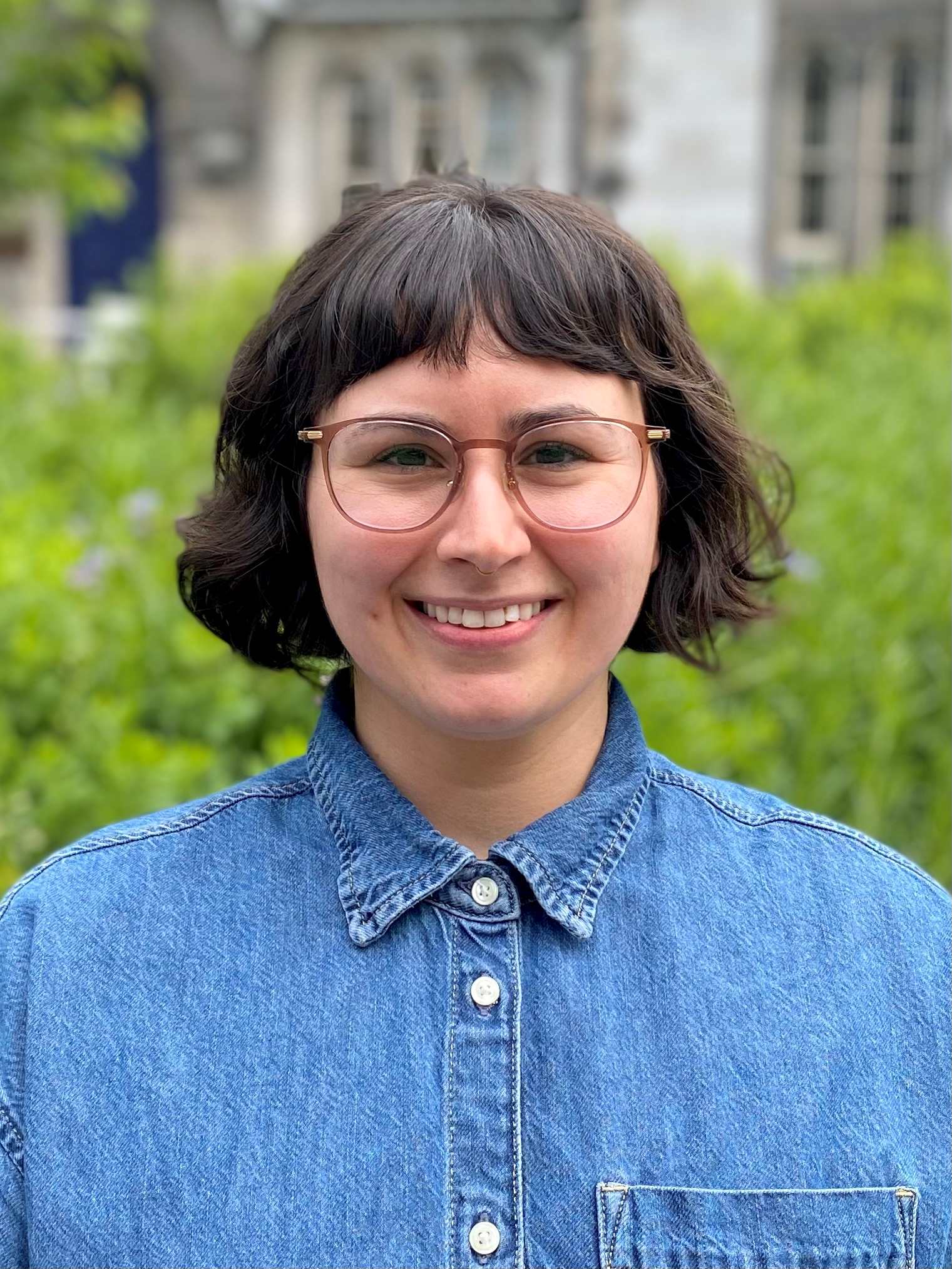 Headshot of Steph with short hair and a button-up shirt. She is smiling.