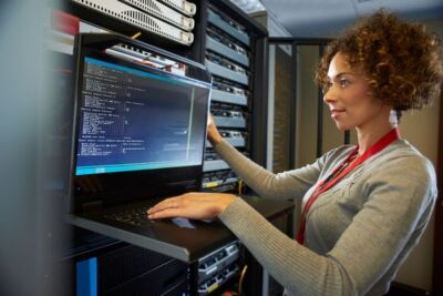 A lady looking at a computer with data reports.